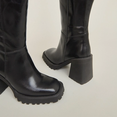 Bottes hautes &agrave; semelles crant&eacute;es et bou... en cuir noir | GENE