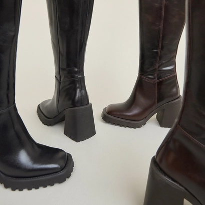 Bottes hautes &agrave; semelles crant&eacute;es et bou... en cuir noir | GENE